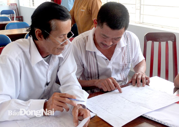 Luật gia Lê Văn Nhân (trái), Trung tâm Tư vấn pháp luật Hội Luật gia tỉnh, tư vấn pháp luật cho người dân liên quan tới hợp đồng vay mượn tiền, chuyển nhượng quyền sử dụng đất. Ảnh: Diễm Quỳnh