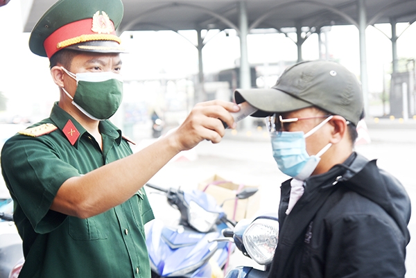 Lực lượng làm nhiệm vụ đo thân nhiệt của người dân tại Chốt kiểm soát số 1 trên tuyến quốc lộ 1, đoạn cầu Đồng Nai (P.Long Bình Tân, TP.Biên Hòa) 