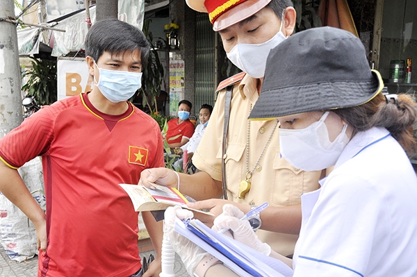 Mỗi chốt kiểm soát gồm 20 người (8 công an, 4 quân sự, 4 thanh tra giao thông, 4 nhân viên y tế), chia làm 4 ca, hoạt động 24/24 giờ các ngày trong tuần kể cả ngày nghỉ, ngày lễ. Các chốt bắt đầu hoạt động từ 0 giờ ngày 2-6-2021. Trong ảnh: Lực lượng y bác sĩ, cảnh sát giao thông lấy thông tin, khai báo y tế lái xe, người đi đường khi lưu thông vào địa phận Đồng Nai