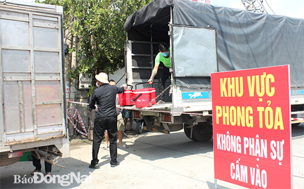 Một công ty chuyên cung cấp suất ăn công nghiệp đang giao thức ăn cho công nhân của một công ty tại P.Tân Hạnh ngay tại chốt kiểm soát. Ảnh: Trần Danh