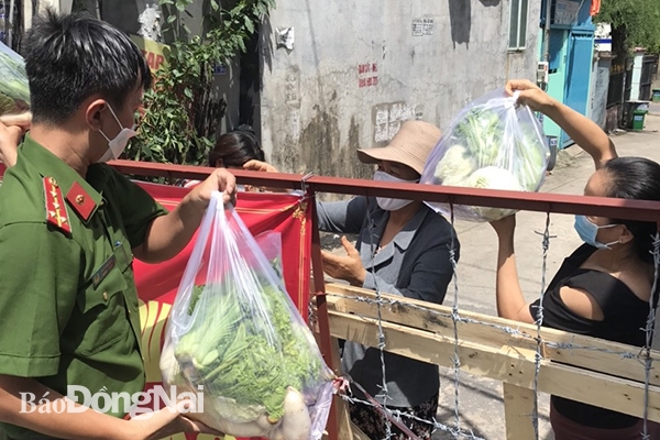 Công an P.Phước Tân, TP.Biên Hòa trao rau, củ, quả cho người dân trong khu vực bị phong tỏa.