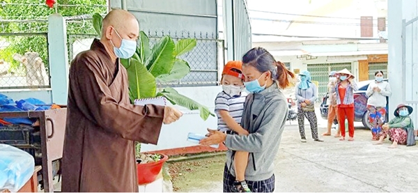  Đại đức Thích An Thuận (P.Trảng Dài, TP.Biên Hòa) trao quà cho những người bán vé số gặp khó khăn trong đại dịch. Ảnh: Tường Vi