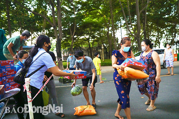 Tặng lương thực cho người dân ở khu cách ly y tế chợ đêm Biên Hùng của P.Trung Dũng, TP.Biên Hòa Ảnh: HUY ANH