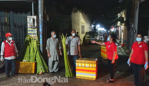 Đại diện Hội chữ thập đỏ tỉnh tặng cá cho đại diện người dân trong vùng phong tỏa tại KP3, P.Tràng Dài, TP.Biên Hòa