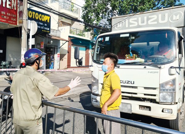 Lực lượng chức năng tại chốt kiểm soát dịch trên đường Nguyễn Ái Quốc (TP.Biên Hòa) nhắc tài xế xe chở hàng hóa thực hiện đúng quy định phòng dịch