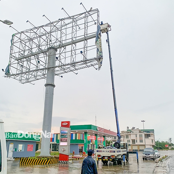 Bảng quảng cáo ven đường, trong cơn mưa chiều 19-7 đã bị gió cuốn bạt quảng cáo lên đường dây 220 kV Long Bình (275) – Long Thành (273) nằm dọc Quốc lộ 51 (P.Tam Phước, TP.Biên Hoà). Ảnh: CTV.