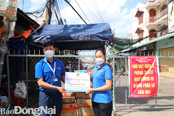 Anh Võ Văn Trung, Phó bí thư Tỉnh đoàn trao sữa cho đại diện Đoàn P.Long Bình để trao cho các em thiếu nhi có hoàn cảnh khó khăn (Ảnh: Huy Anh)