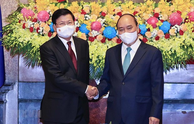 President Nguyen Xuan Phuc (R) welcomes Lao Party General Secretary and President Thongloun Sisoulith during the latter's visit to Vietnam in late June.