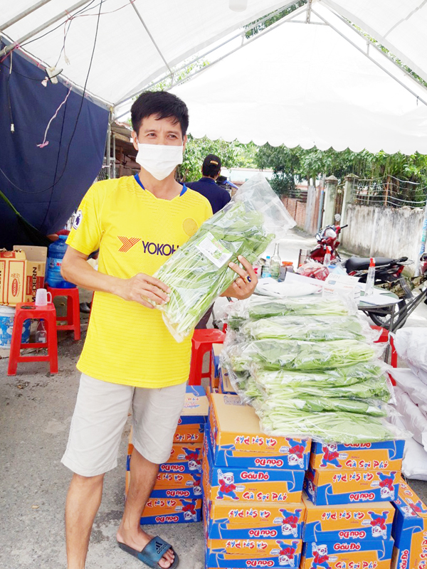Anh Huỳnh Đặng Nhật, công nhân Công ty TNHH Changshin Việt Nam (H.Vĩnh Cửu) nhận nhu yếu phẩm để phân phát cho công nhân. Ảnh: L.MAI