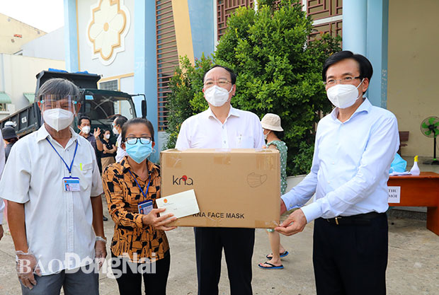Bộ trưởng, Chủ nhiệm Văn phòng Chính phủ Trần Văn Sơn (bìa phải) tặng quà cho đại diện UBND phường Hiệp Hòa.