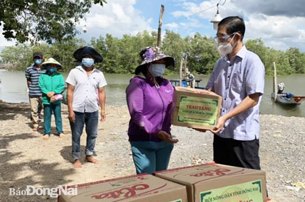  Ông Lê Hữu Thiện, Phó chủ tịch Hội Nông dân tỉnh trao quà cho hội viên nông dân có hoàn cảnh khó khăn tại H.Nhơn Trạch. Ảnh: N.D
