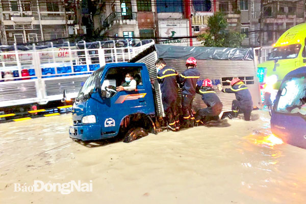 Phòng Cảnh sát phòng cháy, chữa cháy và cứu nạn, cứu hộ (Công an tỉnh) cứu hộ các phương tiện giao thông mắc kẹt do ngập lụt trên quốc lộ 51 (TP.Biên Hòa) sau cơn mưa lớn ngày 26-8. Ảnh: CTV