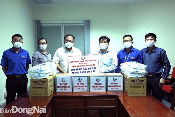 Chánh văn phòng UBND tỉnh Nguyễn Kim Long trao bảng tượng trưng 700 bộ bảo hộ y tế và 100 găng tay cho Bệnh viện dã chiến số 2