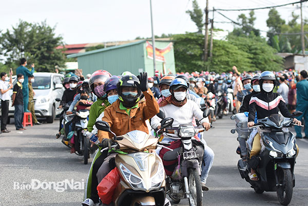 Lao động xếp hàng trật tự để được lực lượng chức năng Đồng Nai hỗ trợ, dẫn đường  về quê. Ảnh: Lan Mai