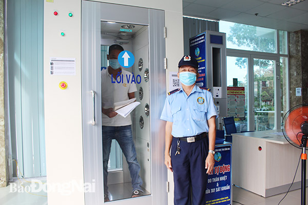 Người dân sát khuẩn trước khi lên phòng làm việc tại Trung tâm Hành chính công tỉnh