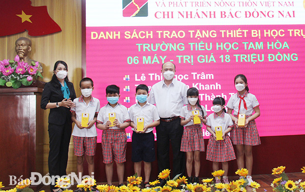Ông Nguyễn Bá Thành, Giám đốc Agribank chi nhánh Bắc Đồng Nai trao tặng thiết bị hỗ trợ học tập trực tuyến cho học sinh khó khăn ở các trường tiểu học trên địa bàn TP.Biên Hòa.