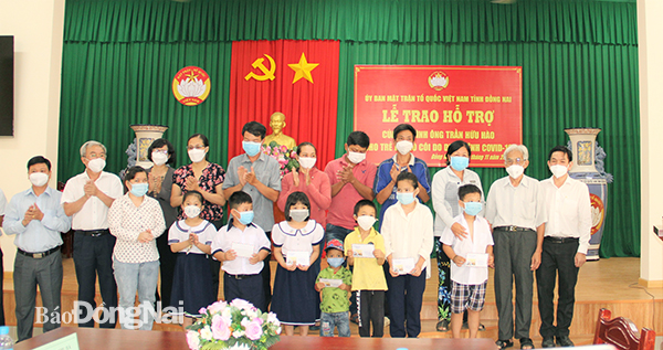 Chủ tịch Ủy ban MTTQ Việt Nam tỉnh Cao Văn Quang cùng ông Trần Hữu Hào trao quà cho các em mồ côi cha mẹ do dịch Covid-19.