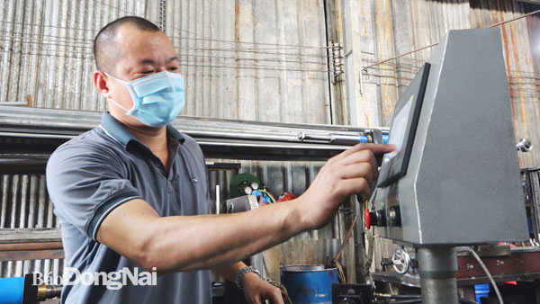 Anh Nguyễn Mạnh Lâm đang điều khiển máy uốn thủy lực 1 trục NC. Ảnh: Hải Yến