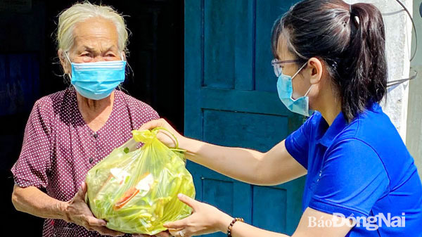 Cô Nguyễn Khanh Nhi trao quà cho người dân khó khăn trong dịch bệnh. Ảnh: H.Thảo
