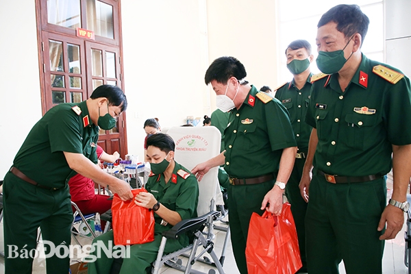 Thiếu tướng Đỗ Hoàng Ngân (bìa trái), Phó chính ủy nhà trường tặng quà học viên tham gia hiến máu