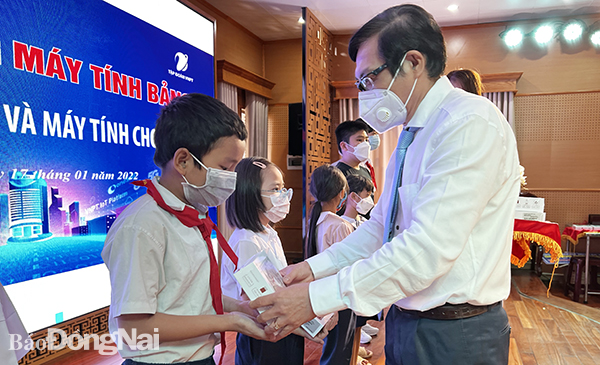 Phó chủ tịch UBND tỉnh Nguyễn Sơn Hùng trao máy tính bảng cho các em học sinh tại buổi lễ