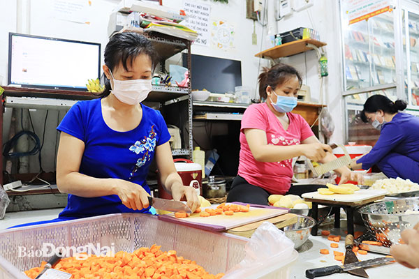 Các thành viên Nhóm thiện nguyện Phước Quý (TP.Biên Hòa) tham gia nấu những suất ăn sáng cho người nghèo và bệnh nhân tại bệnh viện dã chiến. Ảnh: Tố Tâm