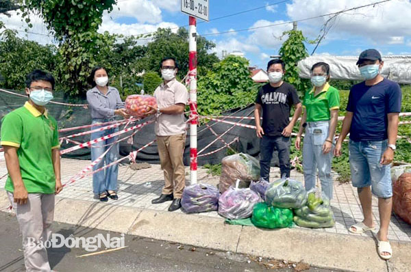 Anh Nguyễn Ngọc Giang San (thứ 3 từ trái sang) cùng nhóm Vạn Sự Tùy Duyên trao quà cho người dân trong các khu phong tỏa tại TT.Long Thành trong thời điểm dịch bệnh bùng phát năm 2021. Ảnh: Đoàn Phú