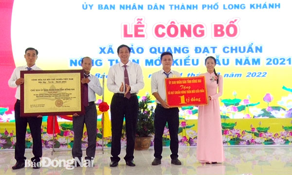 Phó chủ tịch UBND tỉnh Võ Văn Phi trao bằng công nhận xã nông thôn mới kiểu mẫu năm 2021 cho lãnh đạo xã Bảo Quang. Ảnh: Thanh Giang