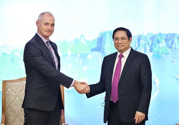 Prime Minister Pham Minh Chinh (R) shakes hands with President of the RMIT University Prof Alec Cameron.