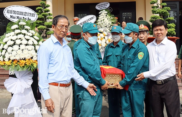 Các đại biểu thực hiện di quách hài cốt liệt sĩ Nguyễn Văn Cường an táng theo quy định