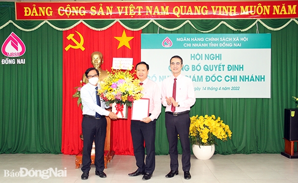  Phó tổng giám đốc Ngân hàng Chính sách xã hội Việt Nam Nguyễn Đức Hải và Phó chủ tịch UBND tỉnh Nguyễn Sơn Hùng trao quyết định và hoa chúc mừng ông Lê Bá Chuyên, tân Giám đốc Ngân hàng Chính sách xã hội Việt Nam chi nhánh tỉnh Đồng Nai