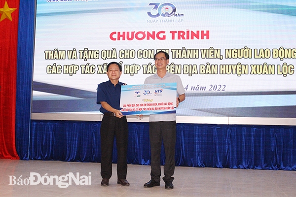 Chủ tịch Liên minh HTX Đồng Nai Đỗ Phước Dũng (bên trái) trao biểu trưng tặng 250 phần quà cho học sinh huyện Xuân Lộc