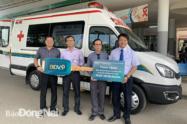 Lãnh đạo BIDV chi nhánh Đồng Nai đại diện trao tặng xe cứu thương cho Bệnh viện đa khoa khu vực Định Quán. (Ảnh: CTV)