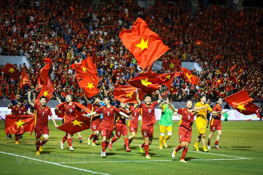 Đội tuyển nữ Việt Nam cầm quốc kỳ, chạy quanh sân vận động Cẩm Phả ăn mừng cùng với hơn 16.000 khán giả trên khán đài. (Ảnh: PV/Vietnam+)