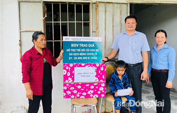 Đại diện BIDV Đồng Nai trao tặng phần hỗ trợ cho em Nguyễn Minh Phúc (ngụ P.Xuân Tân, TP.Long Khánh) có hoàn cảnh khó khăn, mồ côi cả cha lẫn mẹ. Ảnh: CTV