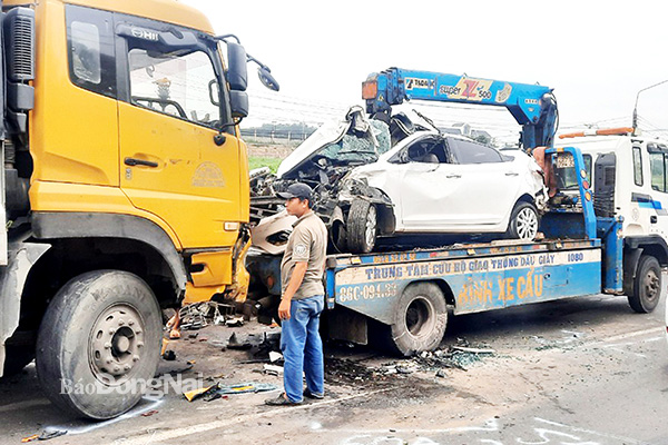 Cơ quan chức năng di dời các phương tiện bị tai nạn trong vụ tông xe liên hoàn của 5 xe ô tô trên quốc lộ 1 (đoạn qua H.Trảng Bom) sáng 1-7. Ảnh: Phan Trí