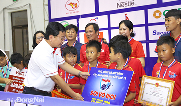 Tổng biên tập Báo Đồng Nai, Trưởng ban Tổ chức giải Đào Văn Tuấn trao bảng tiền thưởng cho đội vô địch U.11 Biên Hòa
