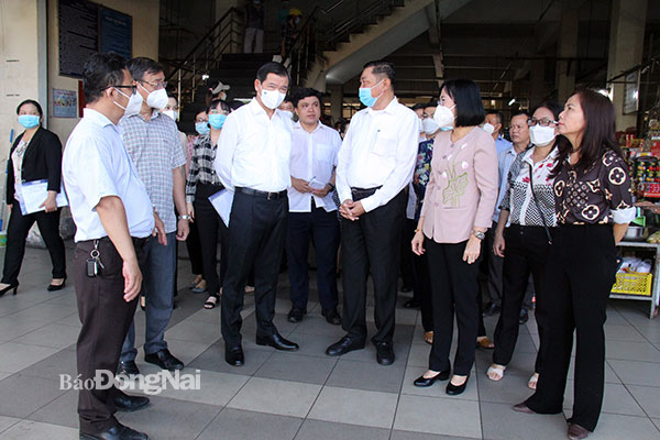 Bí thư Tỉnh ủy Nguyễn Hồng Lĩnh trao đổi với đại diện Ban Quản lý chợ Biên Hòa về tình hình hoạt động của chợ. Ảnh: Hải Quân