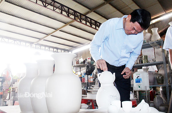 Bí thư Tỉnh ủy Nguyễn Hồng Lĩnh tỉ mỉ quan sát các sản phẩm gốm địa phương. Ảnh: Hải Quân