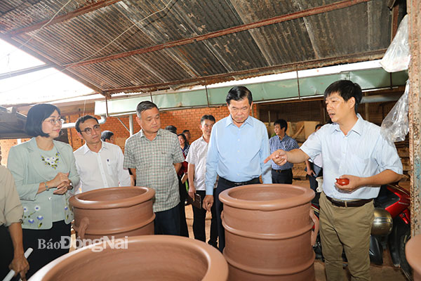 Lãnh đạo Công ty TNHH Gốm Phong Sơn (TP.Biên Hòa) chia sẻ về quy trình sản xuất gốm đất đen tại cơ sở sản xuất của công ty. Ảnh: Huy Anh