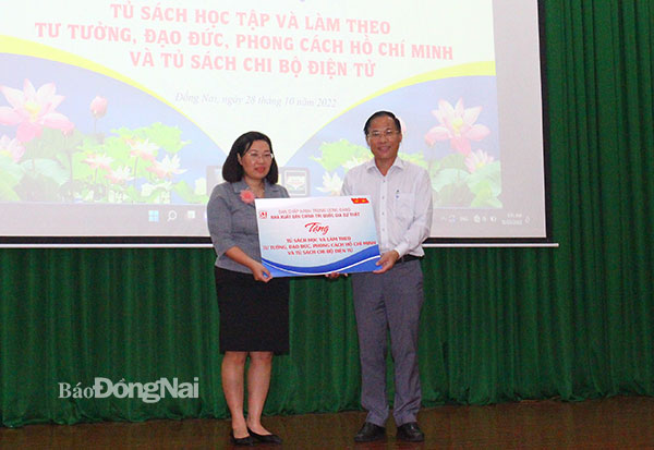 Phó giám đốc NXB Chính trị quốc gia Sự thật Phạm Thị Thinh trao tặng tủ sách cho Trưởng ban Tuyên giáo Tỉnh ủy Phạm Xuân Hà. Ảnh: My Ny