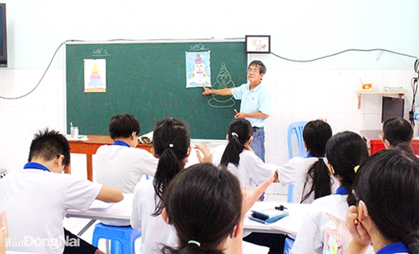 Họa sĩ Nguyễn Quang Hoàng dạy vẽ cho học sinh khiếm thính tại Trường Khiếm thính Hoa Lan. Ảnh: L.Na