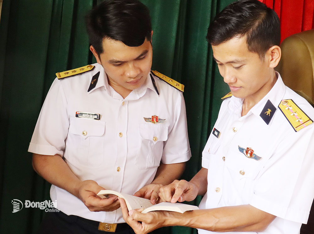 Thượng úy chuyên nghiệp Hồ Văn Nghĩa (phải) trao đổi với trợ lý chính trị những mô hình hiệu quả thực hiện nhiệm vụ