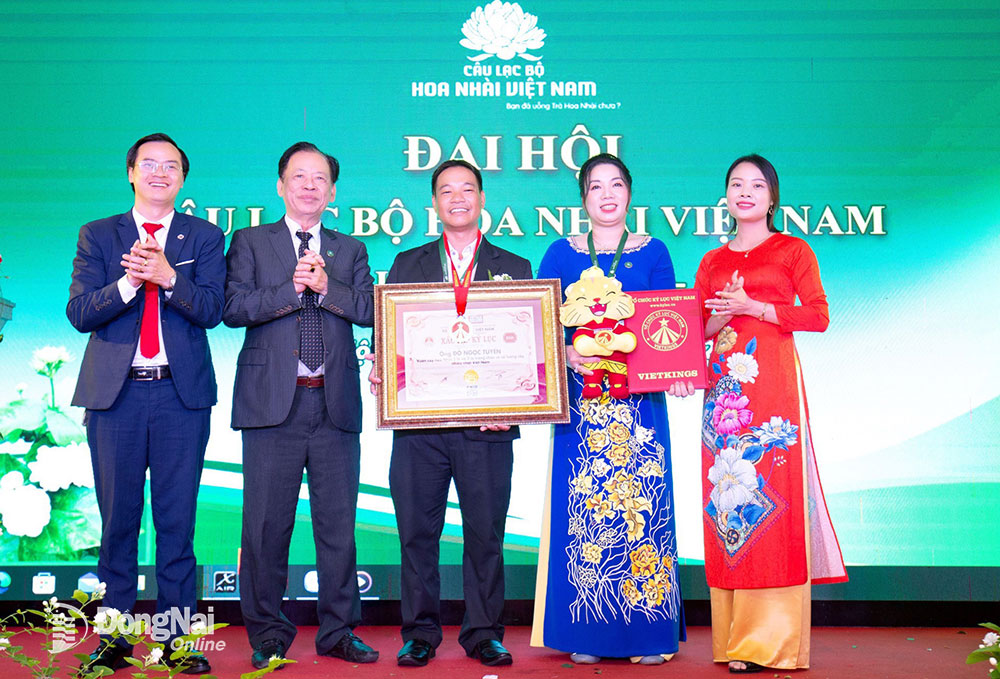 Ông Đỗ Ngọc Tuyển (giữa) cùng vợ (bên cạnh) tại buổi lễ tiếp nhận bằng xác lập và huy chương kỷ lục Việt Nam diễn ra tại Hà Nội. Ảnh: T.NHÂN