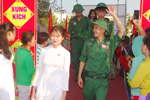 Các tân binh bước qua cầu Vinh Quang để bắt đầu về đơn vị mới. (Ảnh: T.Mai)