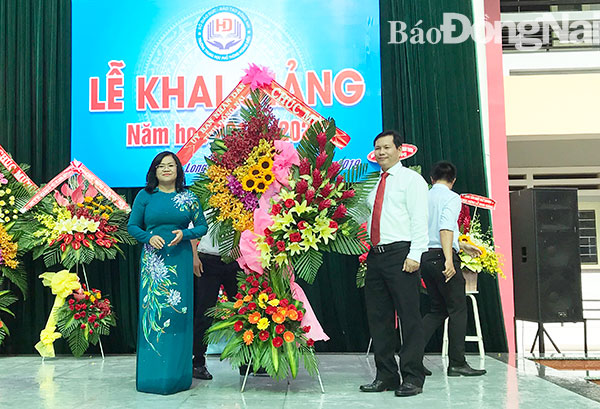 Phó chủ tịch UBND tỉnh Nguyễn Hoà Hiệp tặng lẵng hoa chúc mừng khai giảng năm học mới cho thầy và trò trường THPT Hoàng Diệu. Ảnh: Hải Yến