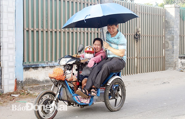 Vợ chồng anh Đỗ Văn Bình, chị Bùi Thị Diệu Hiền (khu Kim Sơn, thị trấn Long Thành, huyện Long Thành) cùng con trai trên chiếc xe ba bánh, ngày ngày đi bán vé số