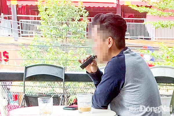 Hiện nay rất dễ bắt gặp những người trẻ sử dụng thuốc lá điện tử ở những nơi công cộng. Trong ảnh: Một thanh niên hút thuốc lá điện tử tại một quán cà phê trên đường Võ Thị Sáu (TP.Biên Hòa). Ảnh: Minh Thành