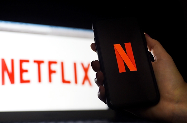 Biểu tượng Netflix trên màn hình máy tính và điện thoại di động tại Arlington, Virginia, Mỹ. Ảnh: AFP/ TTXVN