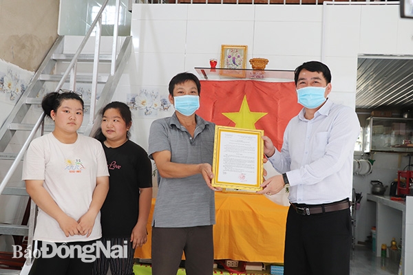 Ông Trần Hoàng Sự, Bí thư Đảng ủy xã Vĩnh Thanh, huyện Nhơn Trạch (bìa phải) trao quyết định bàn giao nhà đại đoàn kết cho ông Nguyễn Văn Quang